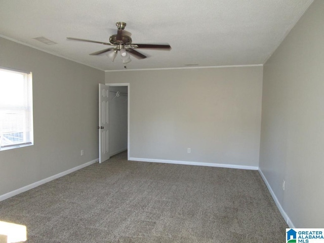 empty room with carpet flooring, ceiling fan, and crown molding