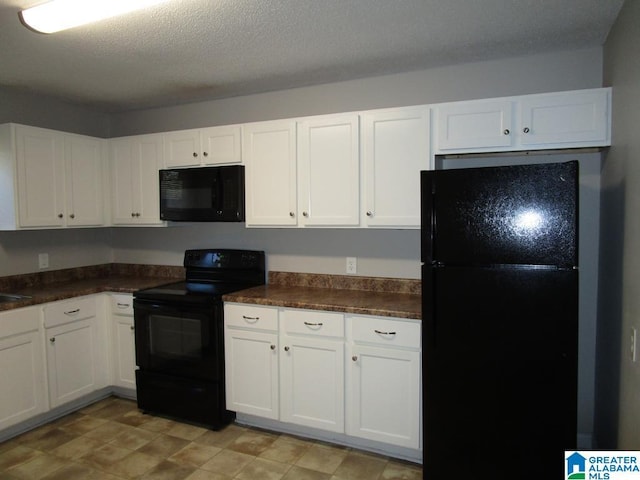 kitchen featuring white cabinetry, black appliances, and a textured ceiling