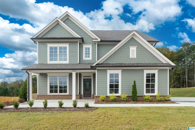 craftsman inspired home with a porch and a front lawn