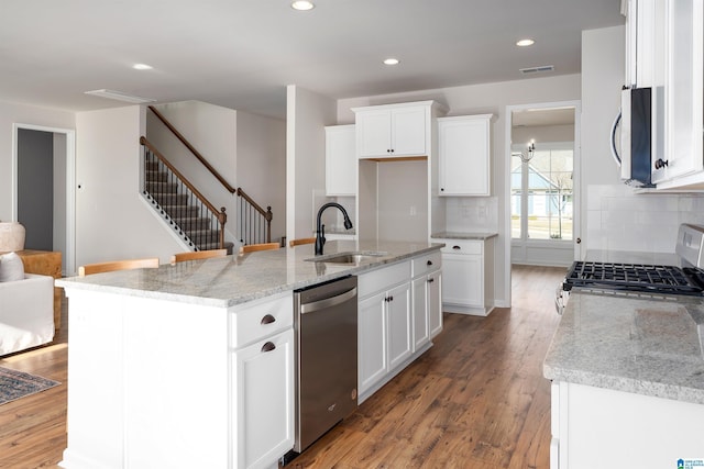 kitchen featuring appliances with stainless steel finishes, a kitchen island with sink, sink, hardwood / wood-style floors, and white cabinetry