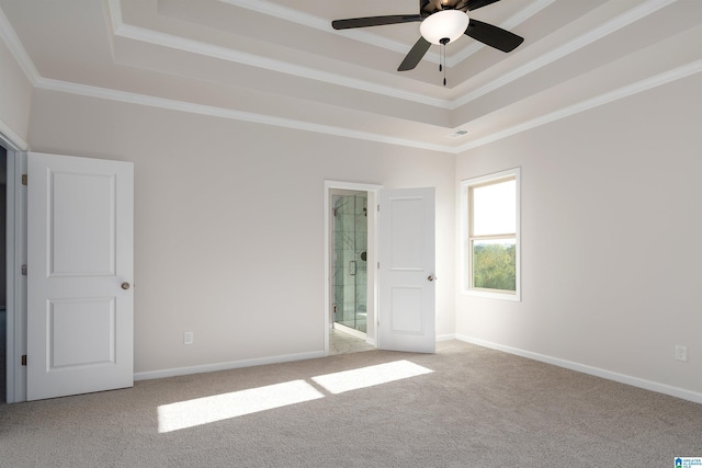 empty room featuring carpet flooring, ceiling fan, ornamental molding, and a tray ceiling