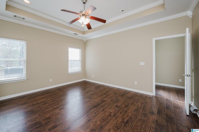 unfurnished room featuring dark hardwood / wood-style floors, a raised ceiling, and ornamental molding