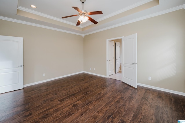 spare room with dark hardwood / wood-style flooring, ceiling fan, a raised ceiling, and ornamental molding