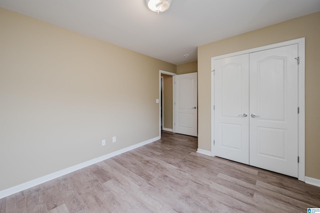 unfurnished bedroom featuring a closet and light hardwood / wood-style flooring