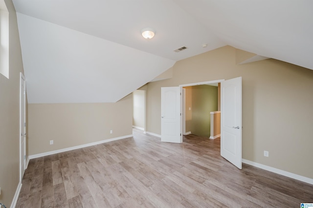 bonus room with light hardwood / wood-style floors and vaulted ceiling