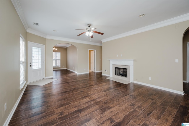 unfurnished living room featuring a tile fireplace, crown molding, ceiling fan, and dark hardwood / wood-style floors