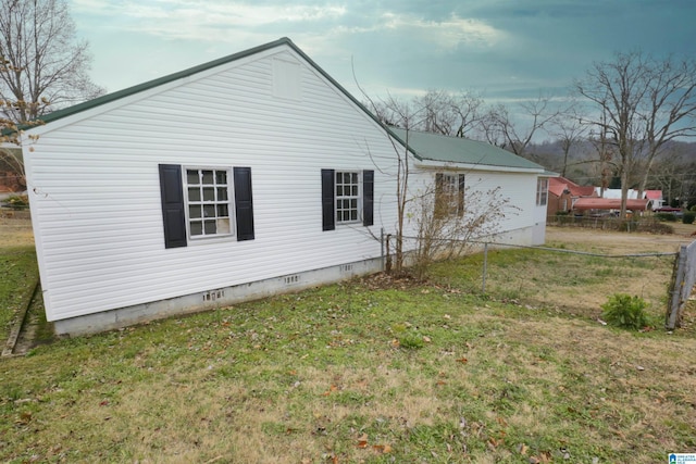 view of side of home with a yard