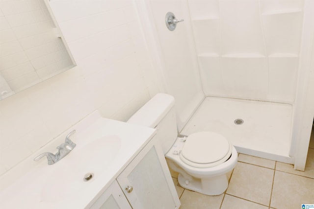 bathroom featuring walk in shower, vanity, tile walls, tile patterned flooring, and toilet