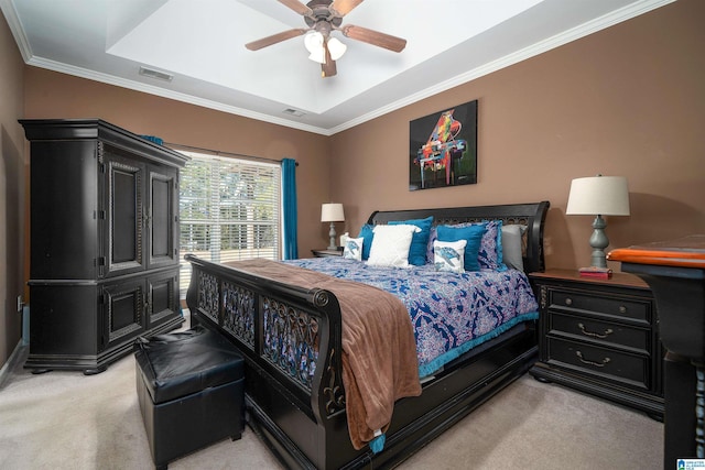 carpeted bedroom with ceiling fan, ornamental molding, and a tray ceiling