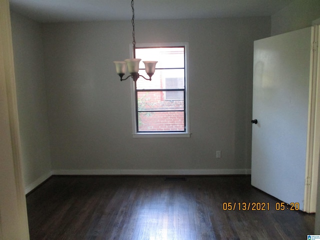 unfurnished dining area with dark hardwood / wood-style floors and an inviting chandelier