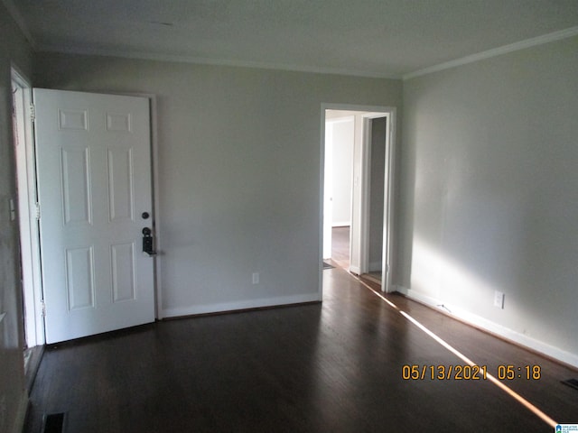 spare room featuring dark hardwood / wood-style flooring and ornamental molding