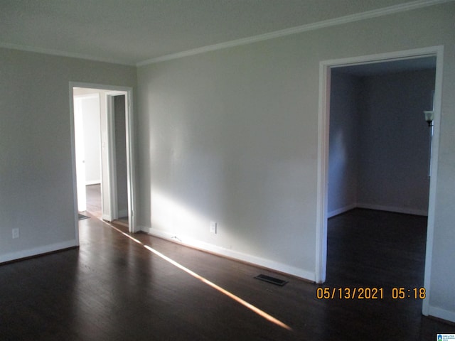 unfurnished room featuring dark hardwood / wood-style flooring and ornamental molding