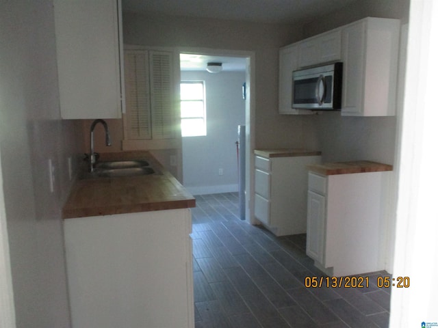 kitchen featuring white cabinetry, sink, and dark wood-type flooring