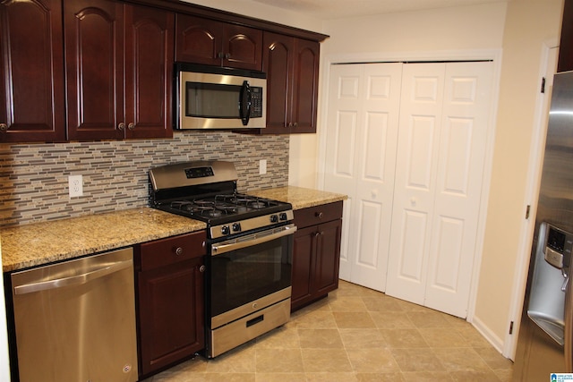 kitchen with light stone counters, stainless steel appliances, and tasteful backsplash