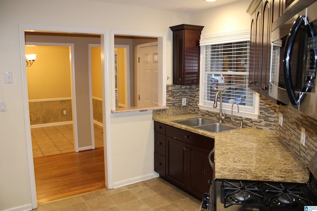 kitchen with decorative backsplash, dark brown cabinetry, light hardwood / wood-style floors, and sink