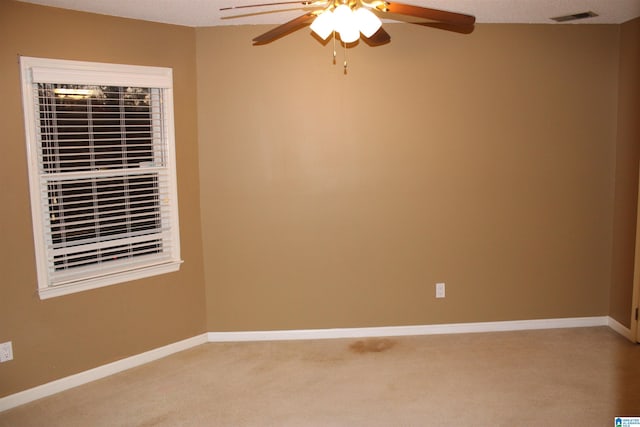 carpeted empty room with ceiling fan and a textured ceiling