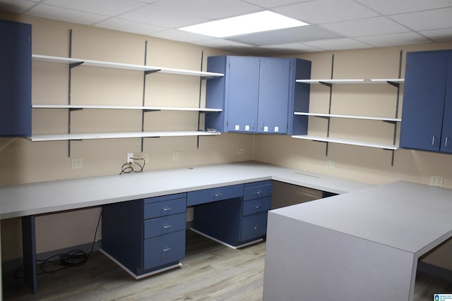 unfurnished office featuring light hardwood / wood-style floors and a drop ceiling