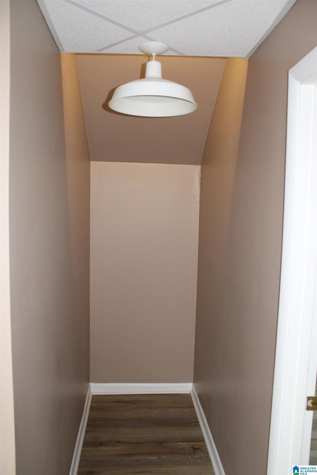 interior space featuring a drop ceiling and dark wood-type flooring