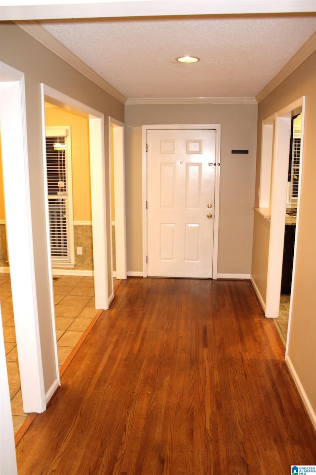 corridor featuring a textured ceiling, crown molding, and dark wood-type flooring