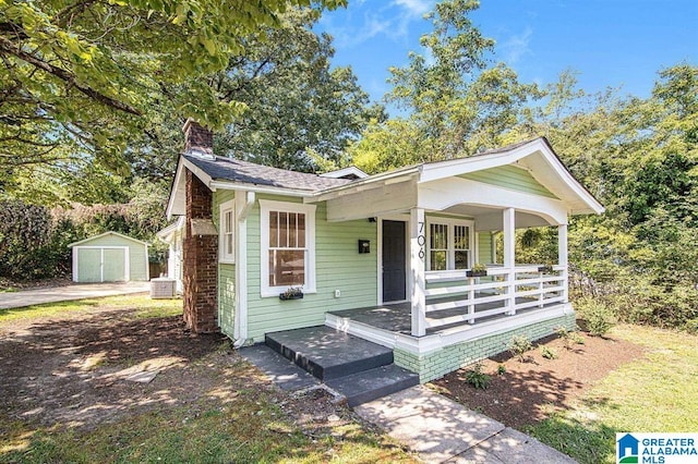 view of front of home with a storage unit and a porch