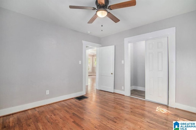 unfurnished bedroom with hardwood / wood-style floors, ceiling fan, and a closet