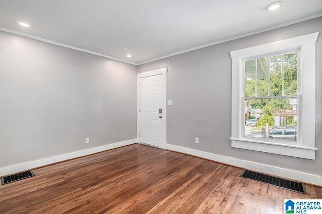 empty room featuring wood-type flooring and ornamental molding