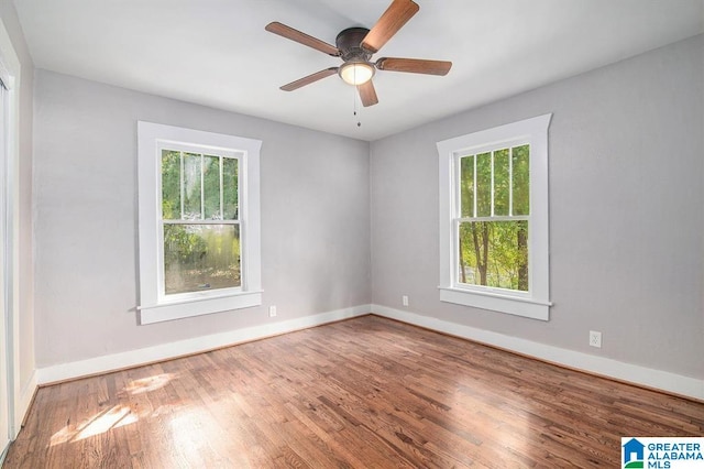 empty room featuring hardwood / wood-style floors, ceiling fan, and a healthy amount of sunlight