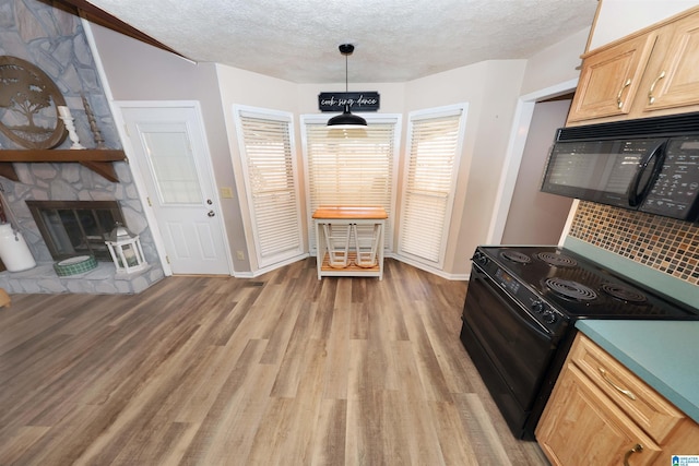 kitchen featuring a textured ceiling, black appliances, light brown cabinets, light hardwood / wood-style flooring, and hanging light fixtures