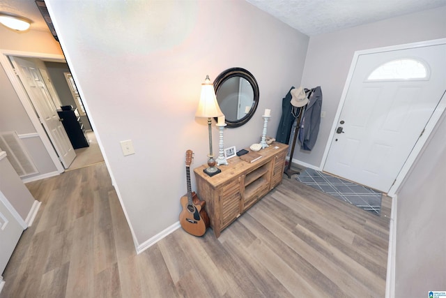 entryway with hardwood / wood-style floors and a textured ceiling