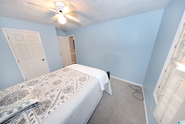 bedroom with ceiling fan, light colored carpet, and a textured ceiling