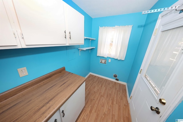 laundry room featuring hookup for a washing machine, cabinets, and light hardwood / wood-style floors