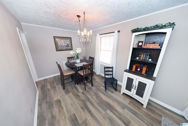 dining room with crown molding, a chandelier, a textured ceiling, and hardwood / wood-style flooring