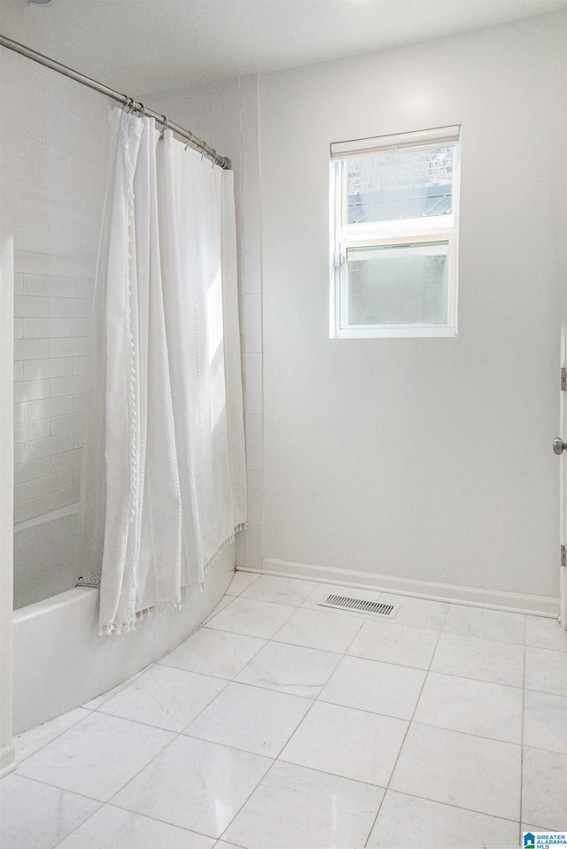 bathroom with tile patterned flooring and shower / bath combo