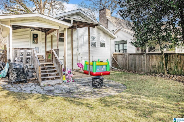 back of house featuring a lawn and ceiling fan