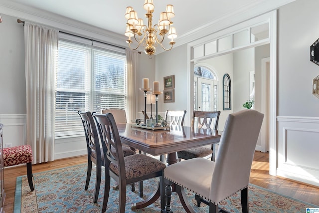 dining space with a chandelier, light hardwood / wood-style flooring, and ornamental molding