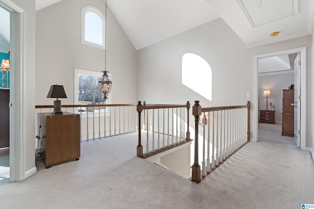 corridor featuring light colored carpet and high vaulted ceiling