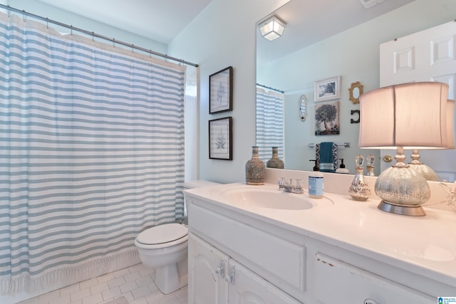 bathroom with tile patterned flooring, vanity, and toilet