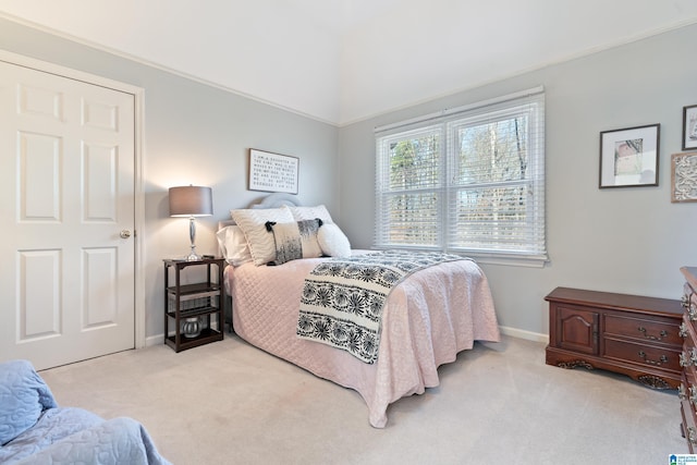 bedroom featuring light colored carpet and lofted ceiling