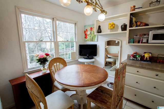 tiled dining space featuring an inviting chandelier