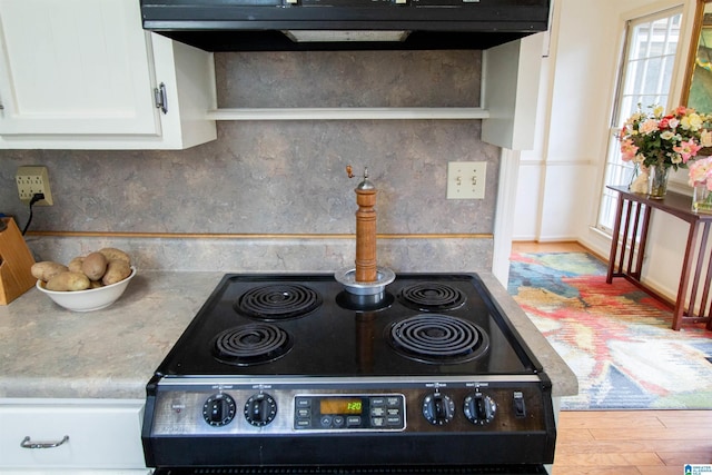 kitchen featuring white cabinets, light hardwood / wood-style floors, and range