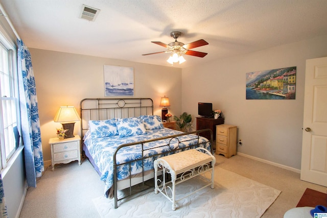 bedroom featuring ceiling fan, carpet, and a textured ceiling