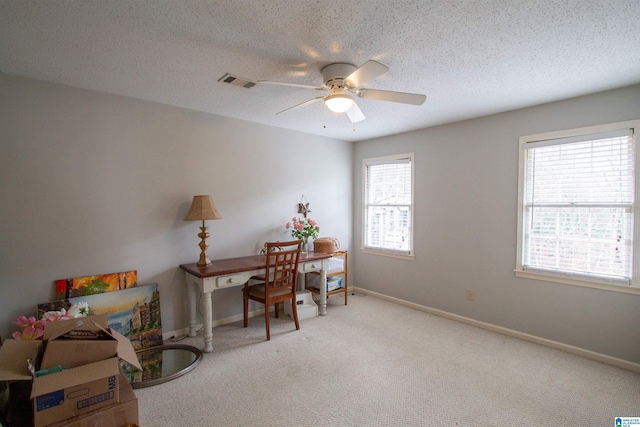 carpeted office space with ceiling fan and a textured ceiling