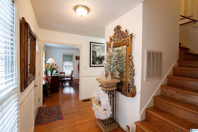 entryway with a textured ceiling and light wood-type flooring