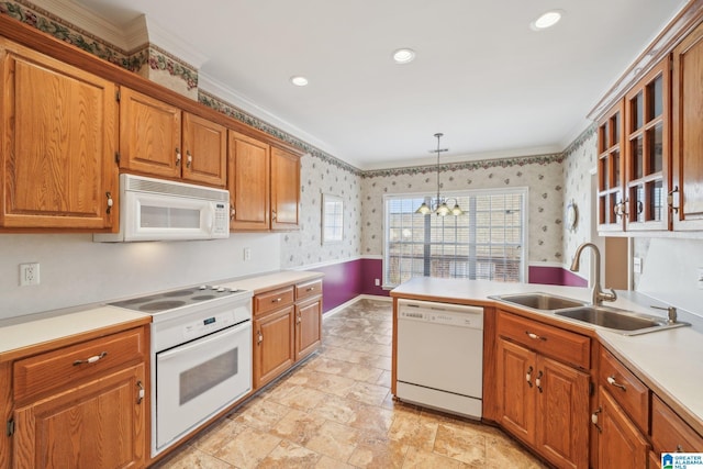 kitchen with sink, a chandelier, decorative light fixtures, white appliances, and ornamental molding