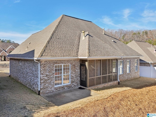 back of house with a lawn, a sunroom, and a patio area