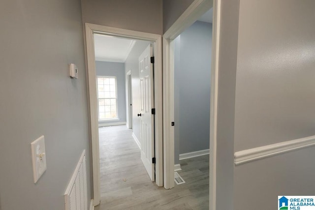 hall featuring crown molding and light hardwood / wood-style floors