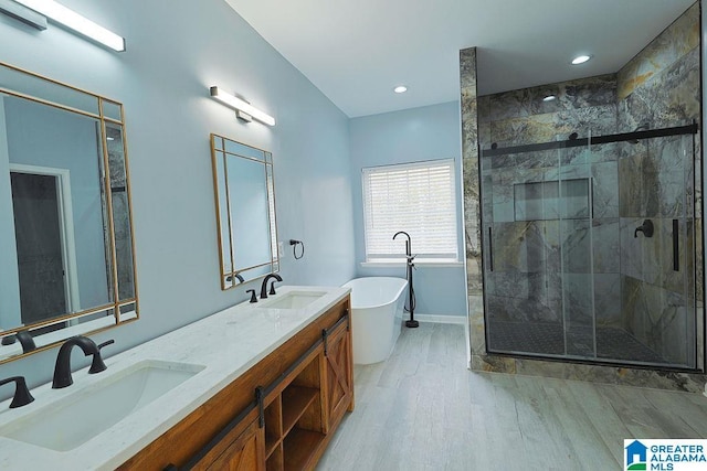 bathroom with hardwood / wood-style flooring, vanity, and plus walk in shower