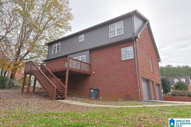 back of property with a wooden deck and a garage