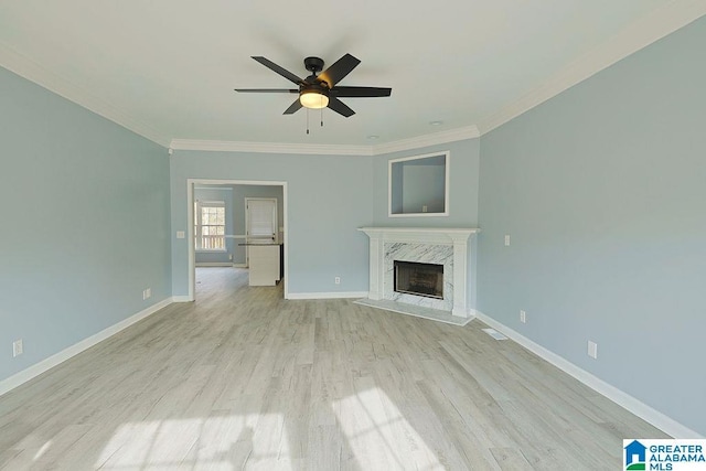 unfurnished living room with crown molding, ceiling fan, a fireplace, and light hardwood / wood-style floors