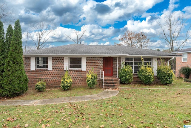 single story home featuring a shingled roof, a front lawn, and brick siding